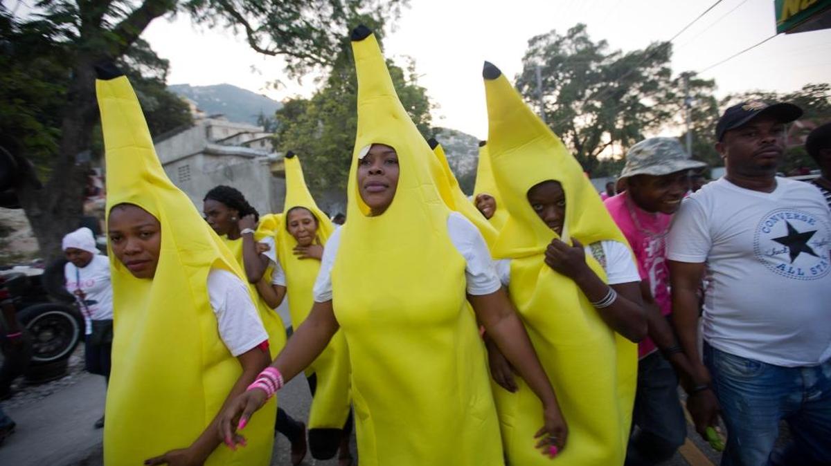 Seguidores del candidato presidencial haitiano Jovenel Moise, disfrados de banana caminan por una calle en Petion-Ville, el viernes.