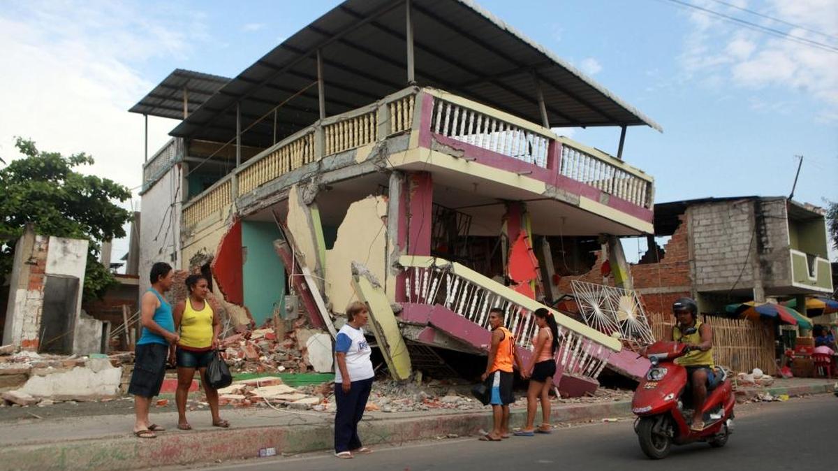 Un grupo de personas habla frente una casa colapsada tras el terremoto de 7,8 de magnitud en el centro de Manta (Ecuador), el viernes 22 de abril de 2016.