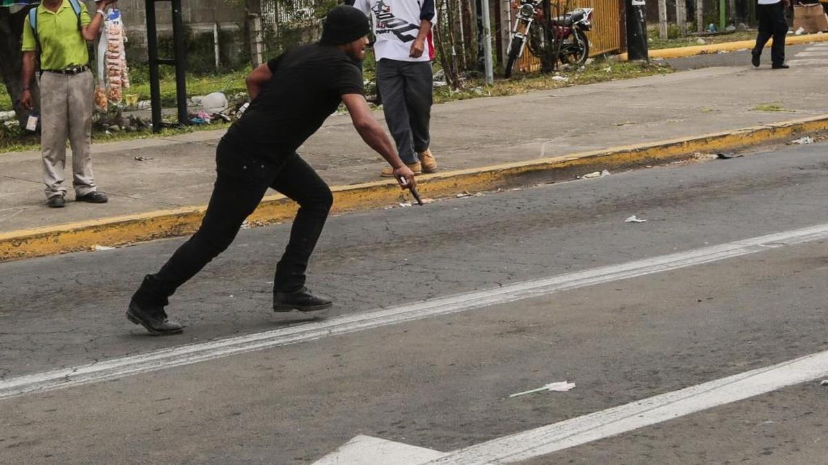 
Un sandinista corre con una pistola en la mano el miércoles cuando es perseguido por opositores, durante una protesta contra el sistema electoral de Nicaragua.
