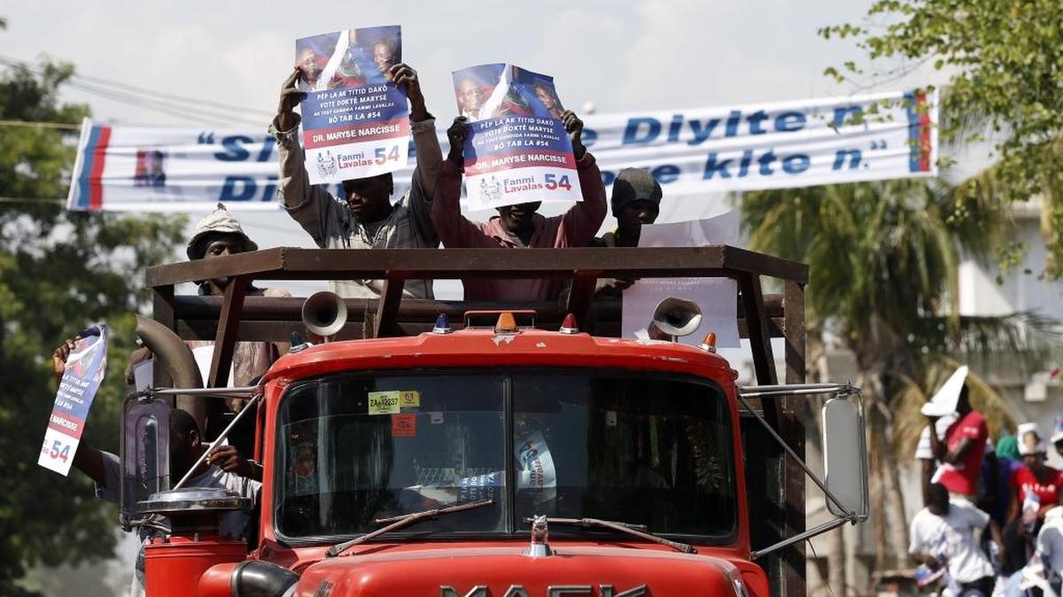 Seguidores de la candidata a la presidencia de Haití, Maryse Narcisse, del partido Familia Lavalas, son vistos el viernes en las afueras de la residencia del ex presidente Jean Bertrand Aristide en Puerto Príncipe.