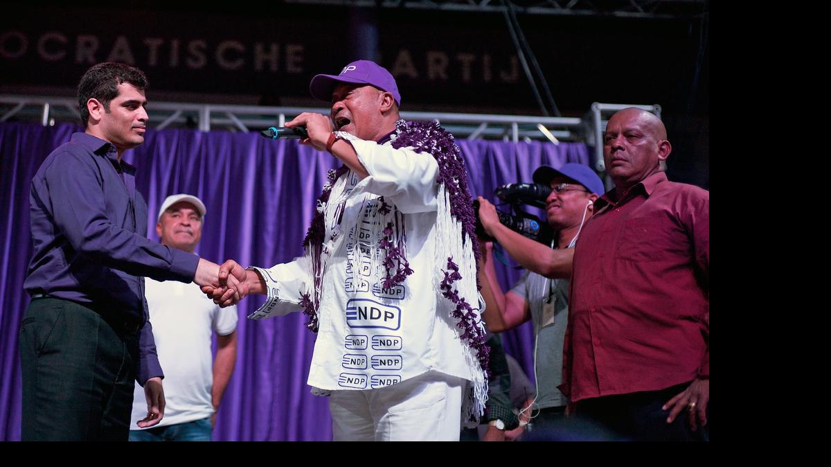 
El presidente de Surinam, Desi Bouterse (cen.), presenta el domingo al ministro de Educación, Michael Ashwin Adhin, durante un mitín de campaña en Paramaribo.
