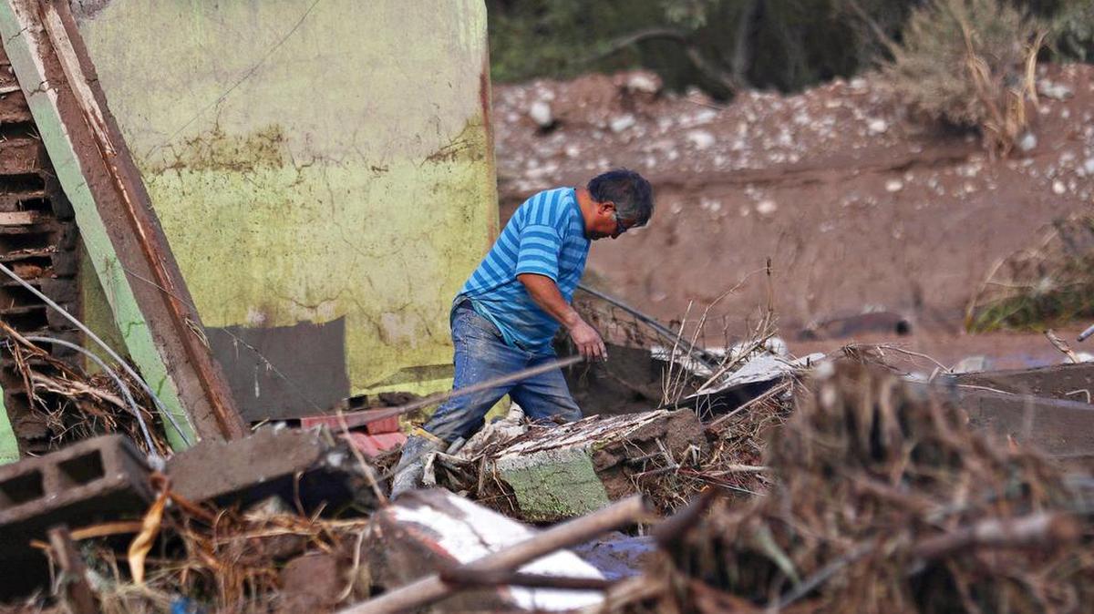 Un hombre camina por escombros arrastrados por el lodo debido a un temporal de lluvia que ya ha dejado dos personas fallecidas y más de 100 damnificados el sábado 13 de mayo de 2017, en Copiapo, región de Atacama (Chile).