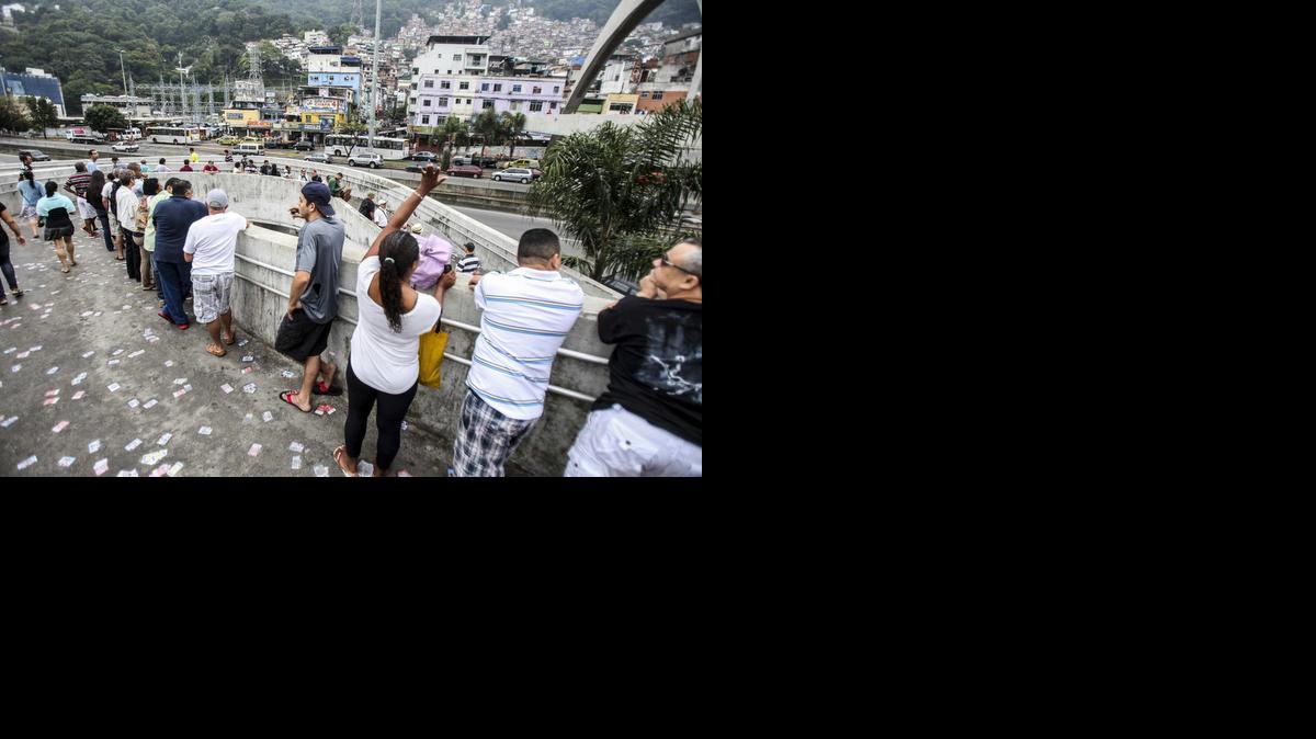 
Un grupo de personas hacen fila frente a la favela de Rocinha el domingo para votar en los comicios para elegir en segunda vuelta su presidente para los próximos cuatro años y 14 de los 27 gobernadores. 
