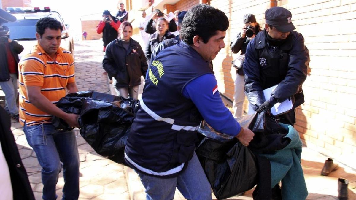 Agentes policiales trasladan el cuerpo de un guardia de seguridad asesinado por la guerrilla EPP, Tacuati, a 400 kms al norte de Asunción, en el 2013.