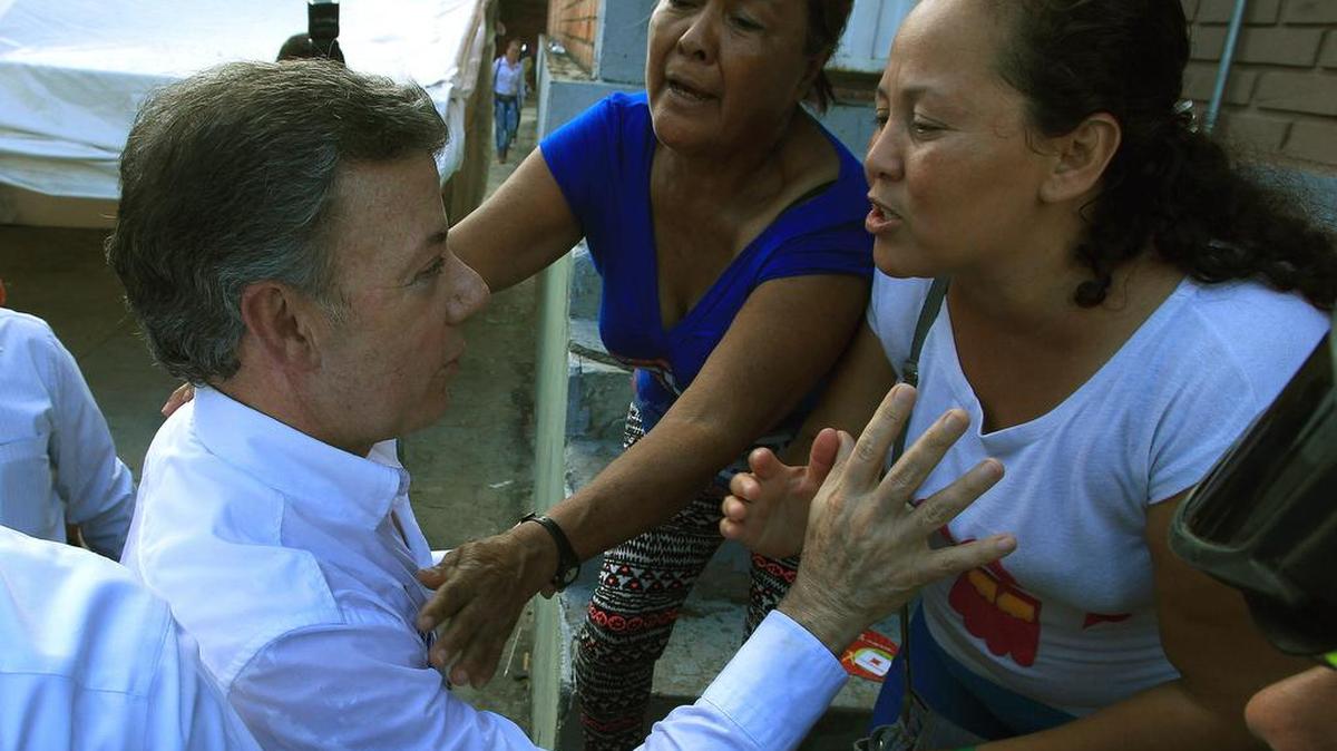 
 El presidente Juan Manuel Santos saluda a unas mujeres deportadas de Venezuela durante su visita al albergue del coliseo Municipal en Cúcuta, Colombia.
