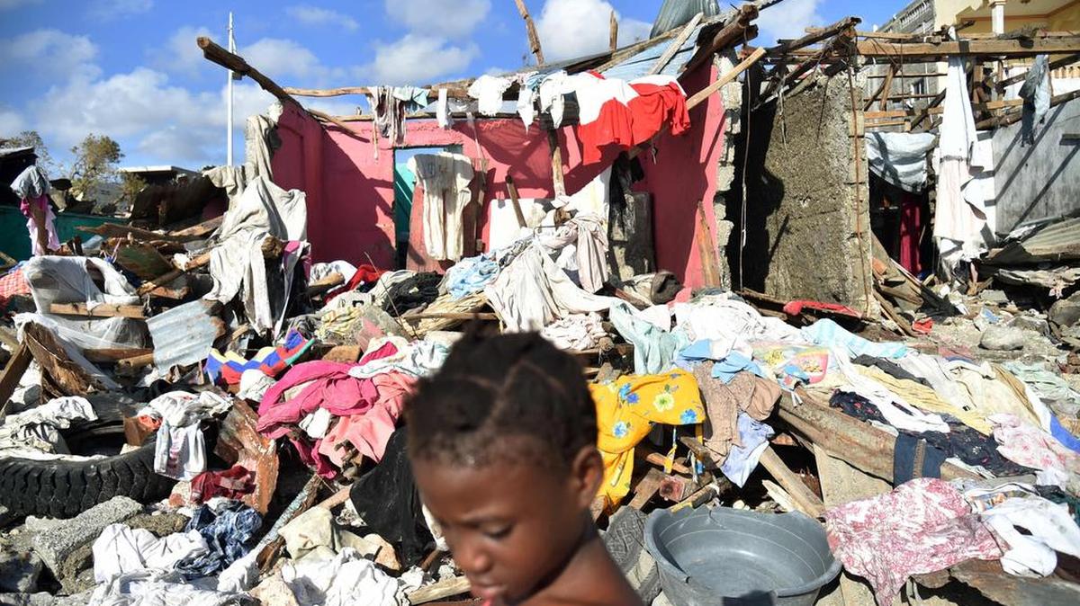 Una niña camina en una playa al lado de los escombros dejados por el huracán Matthew, en Jeremie, Haití, el 8 de octubre de 2016.
