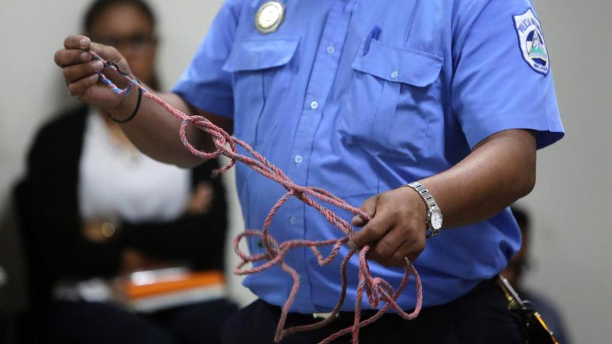 Un oficial de policía muestra una cuerda quemada como prueba del asesinato de Vilma Trujillo García, que fue quemada en una hoguera acusada de estar “poseída” por un demonio, durante una audiencia final por el acusado, el pastor evangélico Juan Gregorio Rocha, en Managua el 25 de abril de 2017.