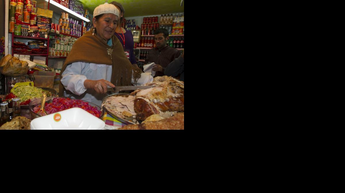 
Zurita Omonte prepara el ‘sandwich de chola’, un emparedado típico de La Paz hecho con finos trozos de carne de cerdo y escabeche, en La Paz, Bolivia. 
