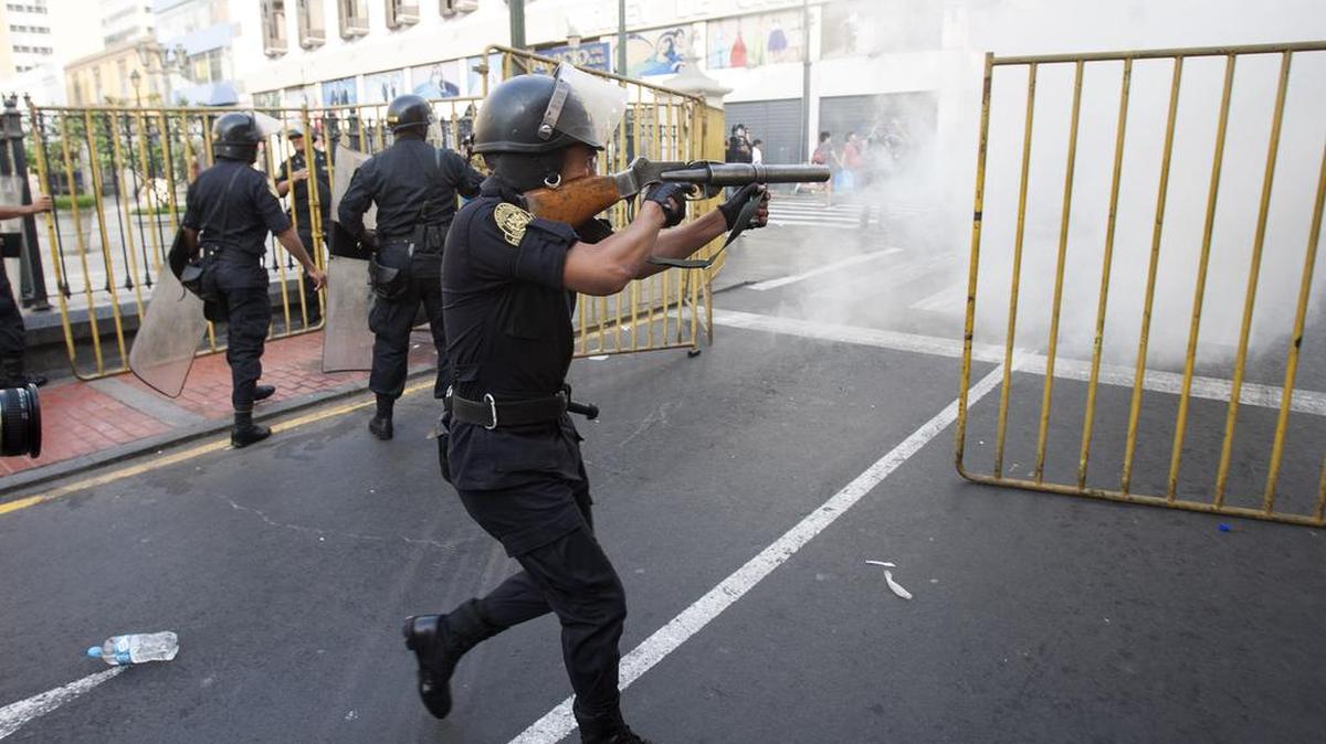 Un miembro de la policía lanza bombas lacrimógenas para dispersar a los manifestantes que intentan llegar hasta el Palacio de Gobierno durante una marcha contra el indulto al expresidente Alberto Fujimori el lunes 25 de diciembre de 2017, en Lima (Perú).