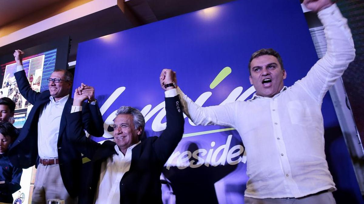 El candidato presidencial oficialista Lenín Moreno (c) celebra junto a su compañero de formula Jorgue Glas (i) y el candidato a la Asamblea Nacional José Serrano (d) al conocer una encuesta que lo da como ganador el domingo 19 de febrero de 2017, en Quito (Ecuador).