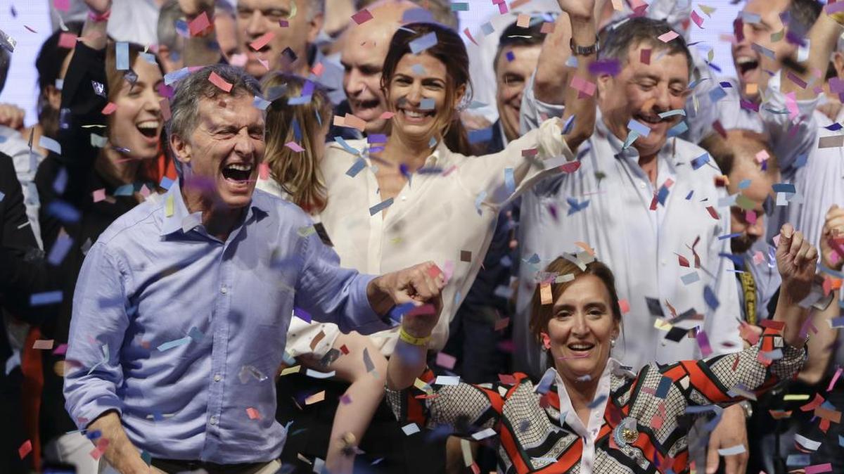 El presidente electo de Argentina, Mauricio Macri, a la izquierda, toma de la mano a su compañera de boleta Gabriela Michetti, al celebrar la victoria en las elecciones del domingo contra el candidato del peronismo Daniel Scioli.