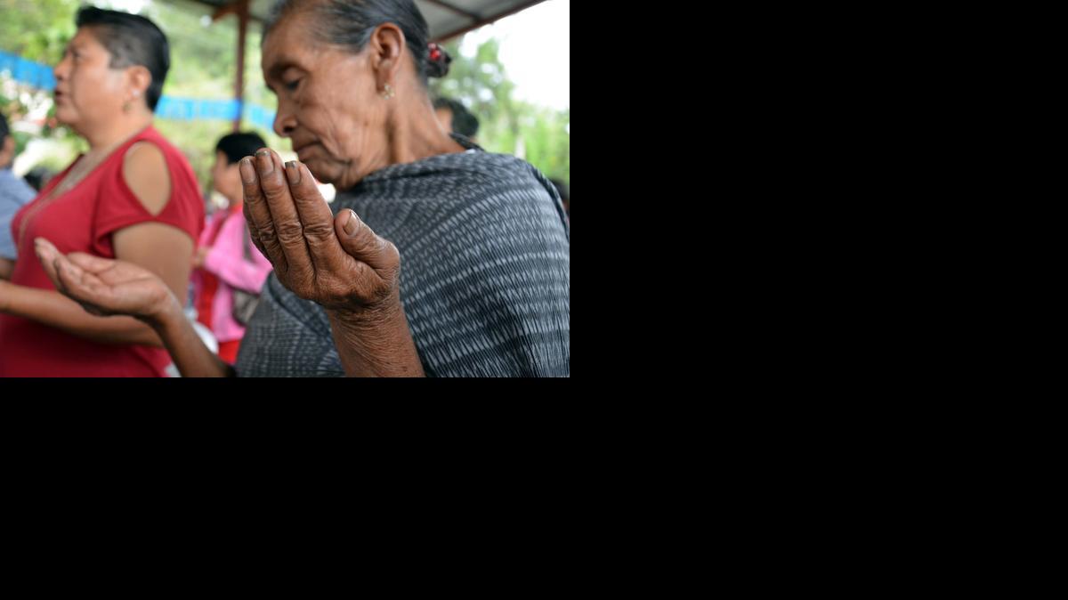 
Una mujer reza durante una misa oficiada en Tixtla, México, por los 43 estudiantes desaparecidos.
