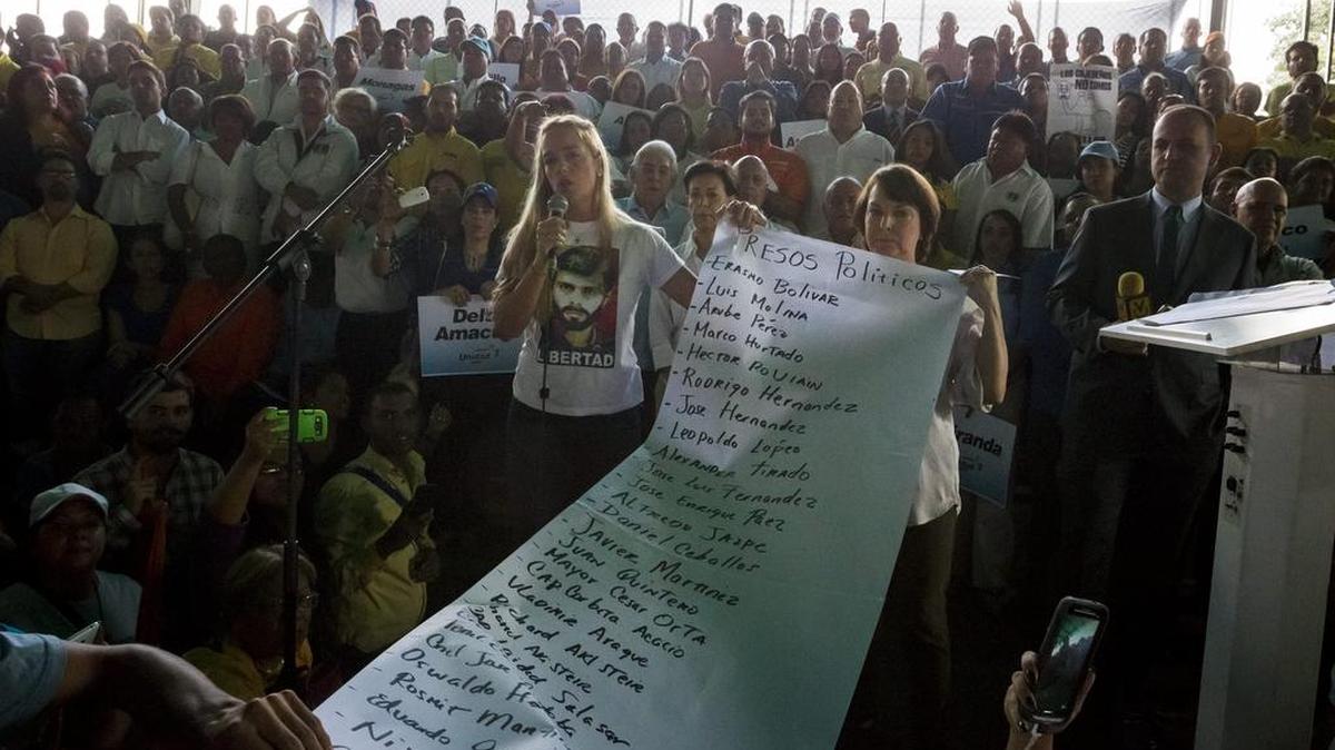 
Mitzy Capriles de Ledezma, esposa del alcalde mayor de Caracas Antonio Ledezma, y Lilian Tintori, esposa del dirigente político Leopoldo López, sostienen un cartel con los nombres de los presos políticos venezolanos durante la presentación de los candidatos de la Mesa de la Unidad Democrática (MUD) para las elecciones parlamentarias del próximo 6 de diciembre, el lunes 17 de agosto de 2015, en Caracas (Venezuela).

