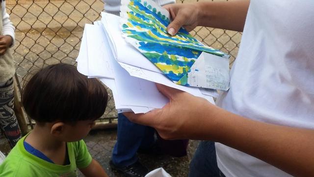 Yennifer Pernía mira los dibujos que su hijo hizo para su padre preso.