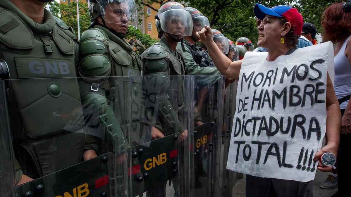 Una mujer protesta frente a miembros de la Guardia Nacional Bolivariana (GNB) el miércoles 18 de mayo de 2016, en la ciudad de Caracas (Venezuela).