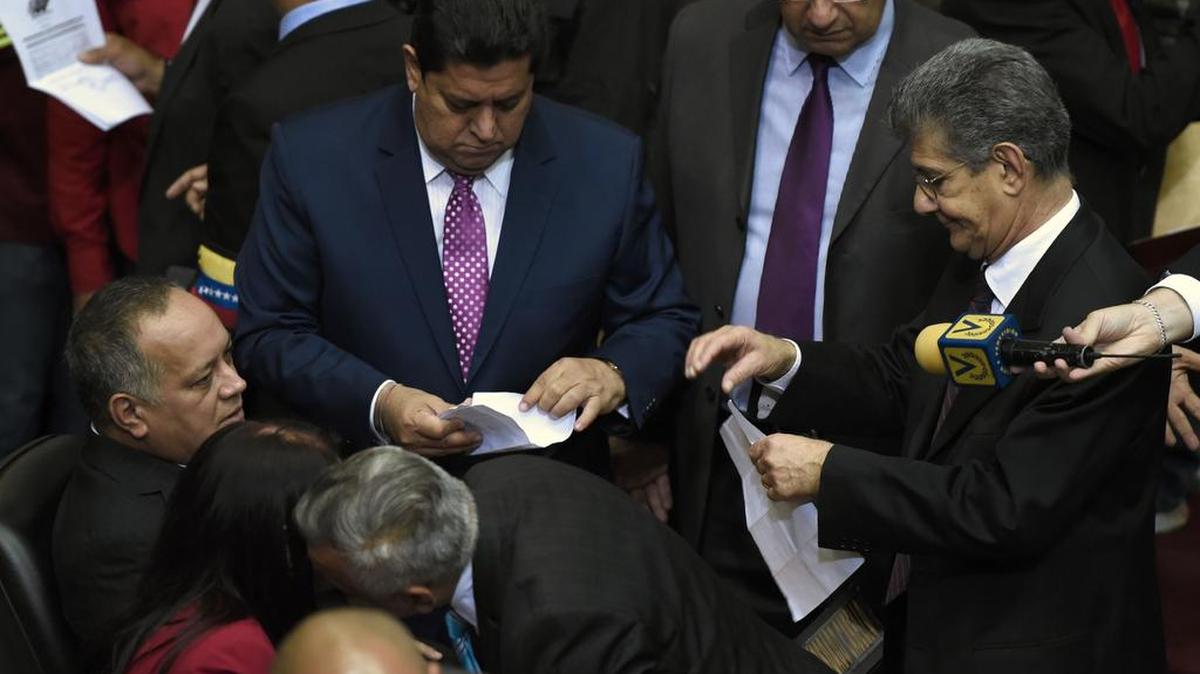Diosdado Cabello, presidente saliente de la Asamblea Nacional, habla con el nuevo presidente del parlamento Henry Ramos Allup (R) en el Parlamento, en Caracas, el 5 de enero de 2016.