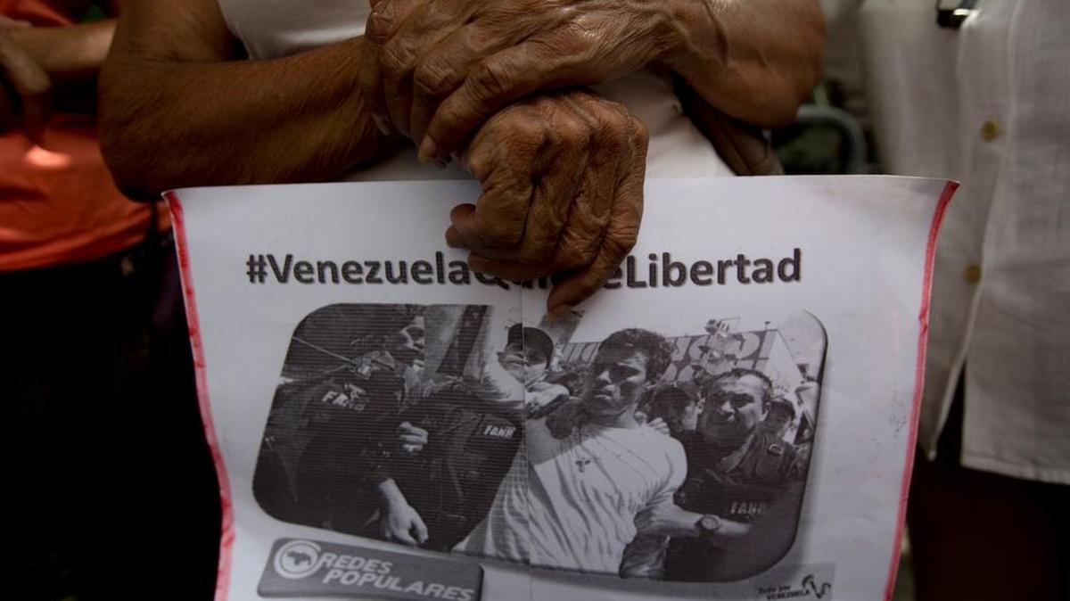 Una simpatizante del líder opositor encarcelado Leopoldo López con un volante con la imagen de López y un hashtag que se lee en español: "Venezuela quiere la libertad" fuera de un tribunal en Caracas, el viernes, 22 de julio de 2016.