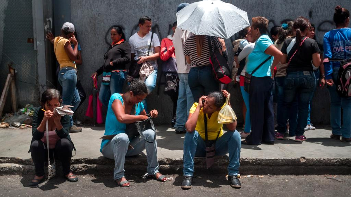 Un grupo de personas hace fila para poder comprar alimentos, el martes 14 de junio de 2016, en el sector popular Catia, en Caracas (Venezuela). 