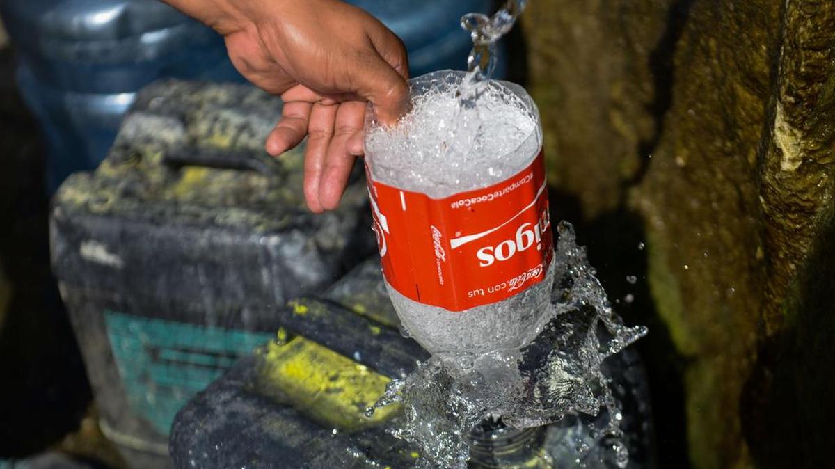 Un hombre llena con agua un embase plástico en la montaña Wuaraira Repana, en Caracas, el 21 de enero del 2016.