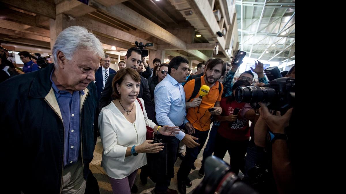 
El ex presidente del Gobierno español, Felipe González (izq.), acompañado de Mitzi Capriles, esposa del alcalde mayor de Caracas Antonio Ledezma, llega al aeropuerto internacional de Maiquetia, Venezuela.