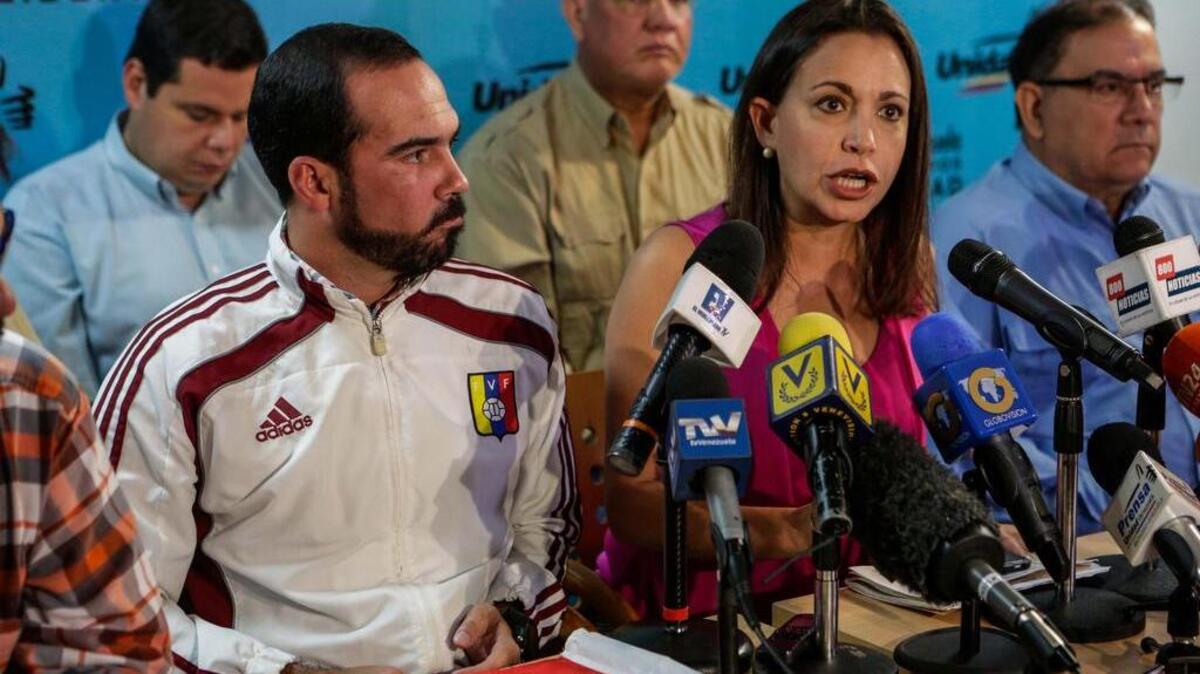 La dirigente opositora María Corina Machado (c), acompañada del secretario nacional de organización del partido Primero Justicia (PJ), Edinson Ferrer (i), habla durante una rueda de prensa de la alianza opositora Mesa de la Unidad Democrática (MUD) el viernes 30 de junio de 2017, en Caracas. La MUD anunció que la coalición opositora suscribirá con la sociedad civil y dirigentes vinculados al chavismo un acuerdo que indicará la ruta hacia "la restitución del orden constitucional".
