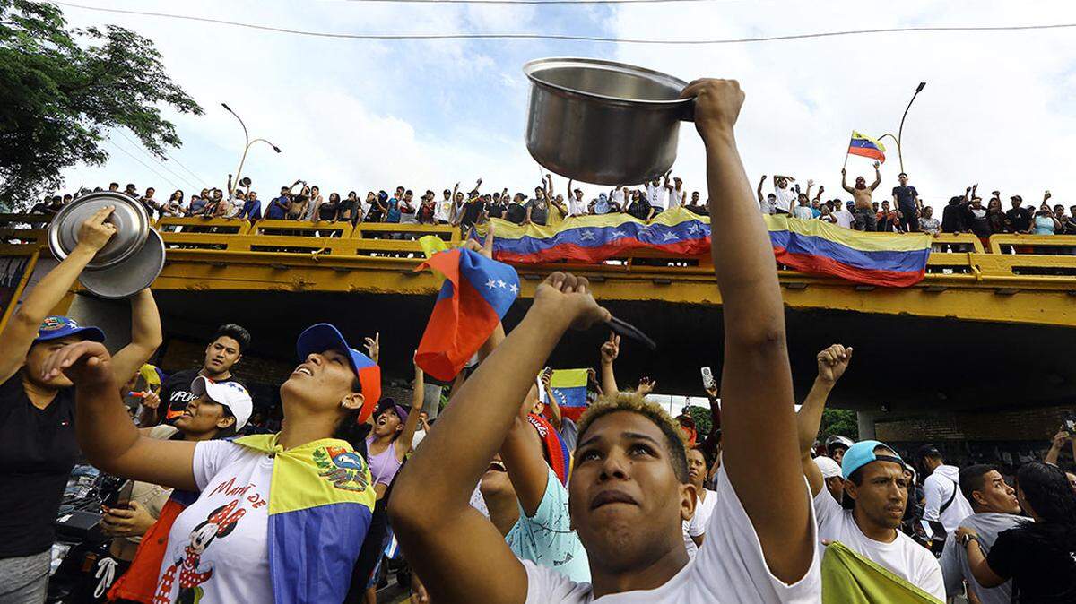 Un hombre golpea una olla durante una protesta contra el gobierno del presidente venezolano Nicolás Maduro en Valencia, estado Carabobo, el lunes, un día después de las elecciones presidenciales. Las protestas estallaron el lunes contra la reelección reivindicada por Maduro, pero cuestionada por la oposición y a nivel internacional.