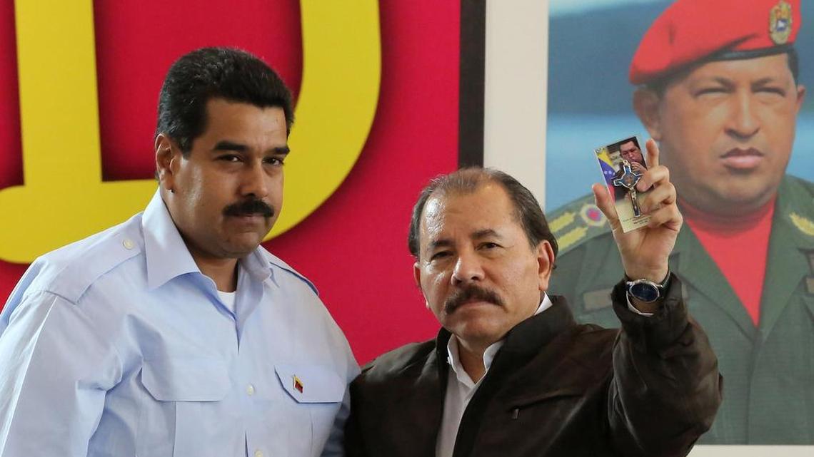El presidente venezolano Nicolás Maduro (izq.) y su colega nicaragüense Daniel Ortega frente a una imagen de Hugo Chávez durante una cumbre de Petrocaribe en Managua en junio del 2013.