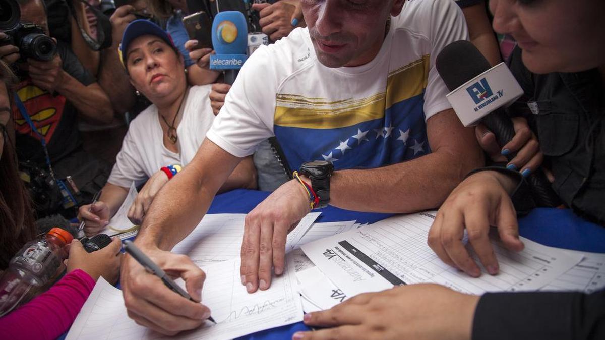 Henrique Capriles, líder opositor y gobernador del estado de Miranda, firma el documento para reactivar el revocatorio contra Maduro.