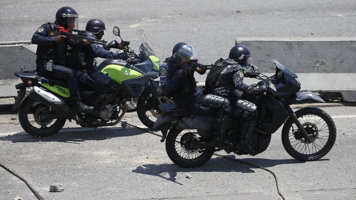 Agentes policiales apuntan sus armas a manifestantes oponentes del régimen de Nicolás Maduro, el 30 de abril del 2019 en Caracas, Venezuela.
