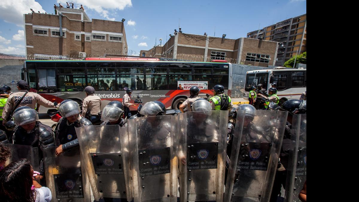 
Miembros de la Policía Nacional Bolivariana (PNB) custodian las inmediaciones de una prisión de su organismo el lunes 27 de abril del 2015, en Catia, un populoso barrio del oeste de Caracas. Un grupo de internos está amotinado desde la noche del domingo en una sede policial de Caracas con un policía como rehén.

