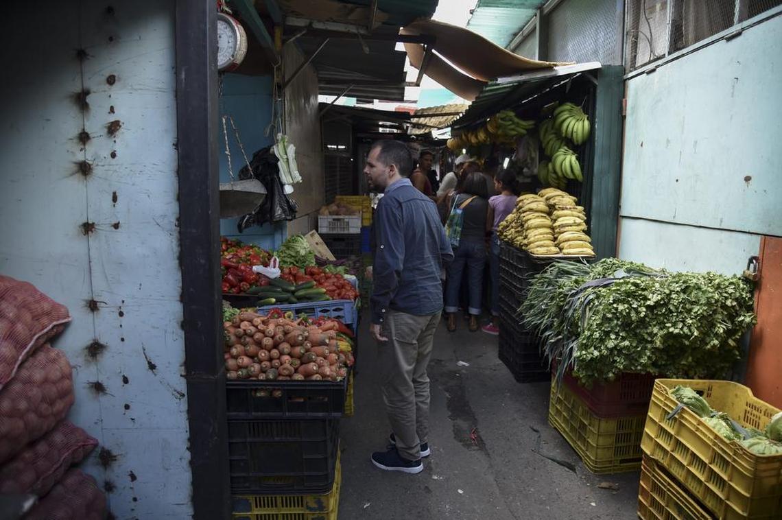 Jairo Colmenares, un empleado del metro de Venezuela, solicita precios de verduras en el mercado en el oeste de Caracas, Venezuela, el 29 de diciembre de 2018.