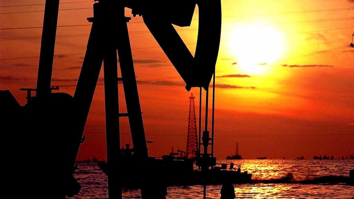 Un pozo de petróleo venezolano es visto durante la puesta de sol en el Lago de Maracaibo, estado Zulia, a unos 700 kilómetros (430 millas) al oeste de Caracas, julio de 1999.