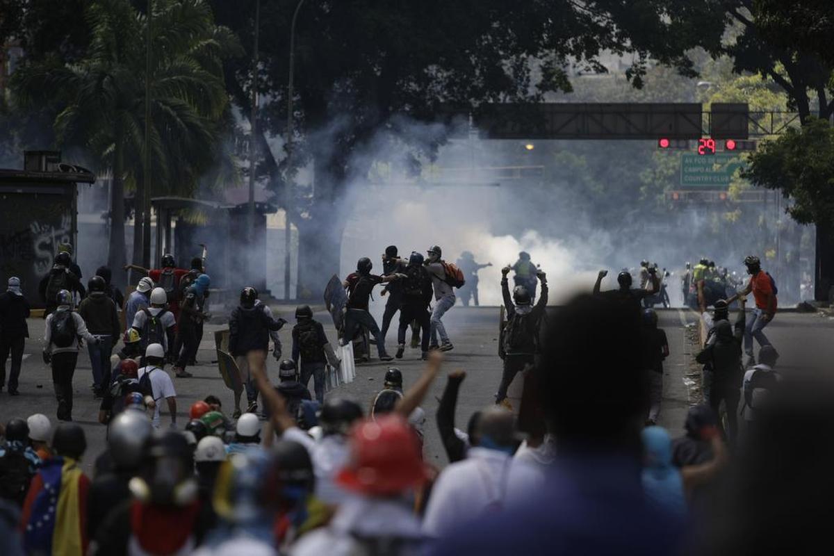 Los manifestantes se enfrentan con la policía antidisturbios durante una marcha hacia la Defensoría del Pueblo en protesta por el presidente Nicolás Maduro en Caracas, Venezuela, el lunes 29 de mayo de 2017.