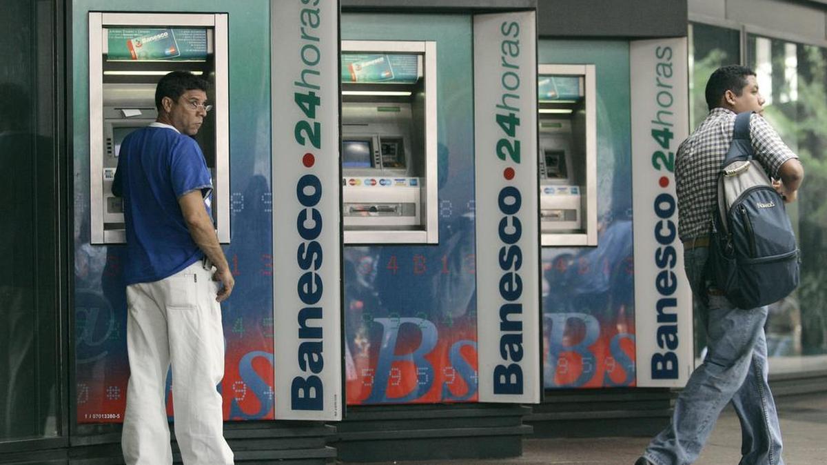 La gente usa cajeros automáticos en el banco Banesco en Caracas, en una fotografía de archivo tomada el 3 de mayo de 2007.