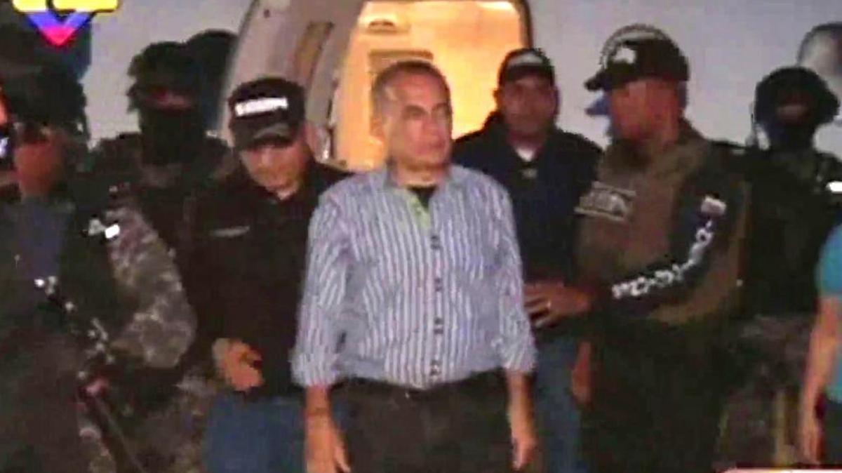 
En una imagen captada del canal del estado VTV, se ve a funcionarios de la Guardia Nacional Bolivariana y del servicio de inteligencia escoltando a Manuel Rosales en el Aeropuerto Internacional de Maracaibo, Venezuela, el 15 de octubre de 2015. Manuel Rosales, líder de la oposición que huyó de Venezuela después que las autoridades lo acusaron de corrupción en 2009, fue arrestado jueves cuando regresaba antes de las elecciones legislativas clave.
