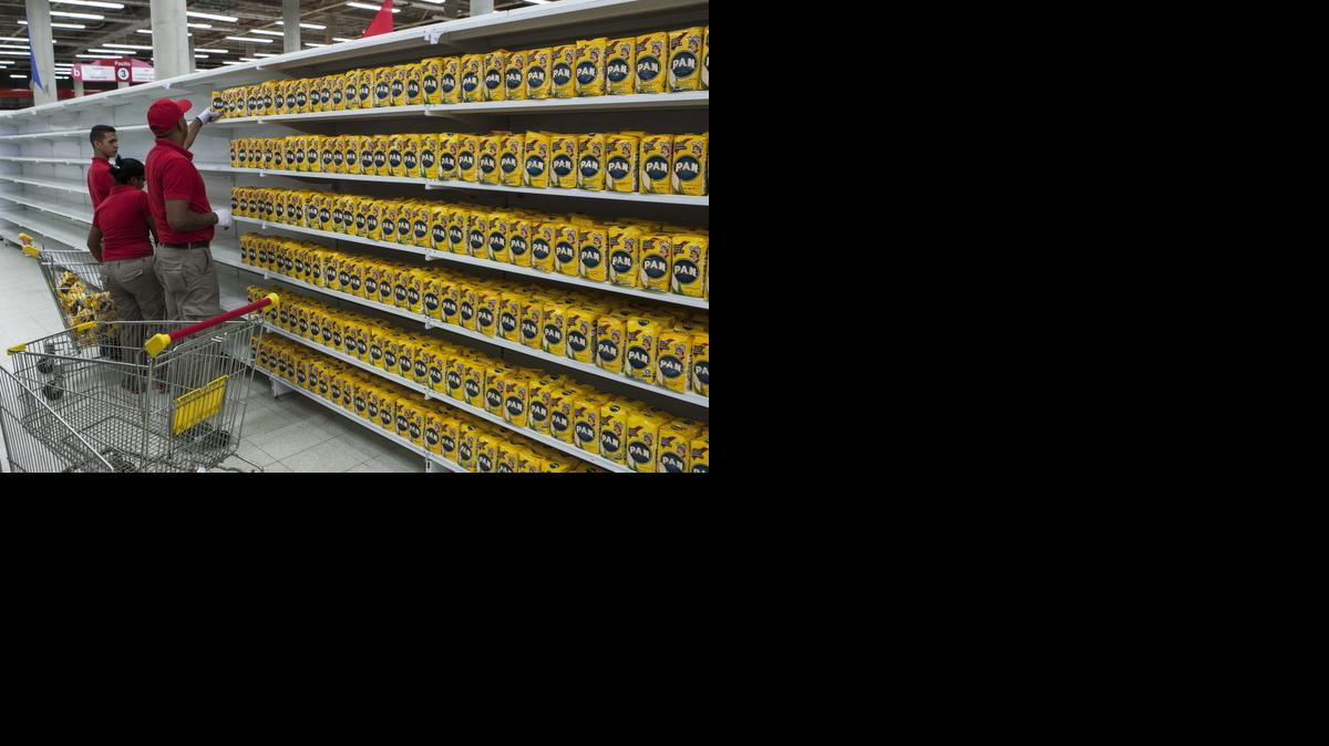 
Trabajadores de un supermercado perteneciente a la red pública de alimentación del gobierno reponen los productos en una estantería, este lunes en Caracas.


