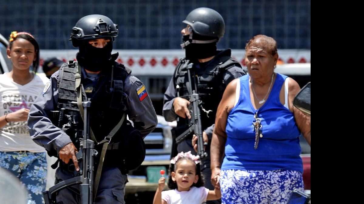 
Miembros de la policía nacional vigilan la entrada a un destacamento de la Policía Nacional Bolivariana de la populosa barriada pobre de Catia, en Caracas, el lunes 27 de abril de 2015.
