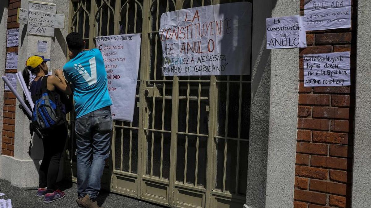 Manifestantes pegan carteles en rechazo a la Asamblea Constituyente el lunes 24 de julio de 2017, en un colegio electoral de Caracas (Venezuela).