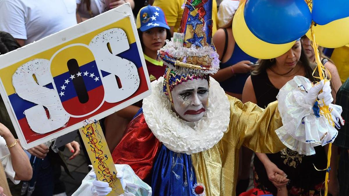 Manifestantes con banderas y carteles cantan durante una manifestación contra el gobierno venezolano en un mitin frente a la Freedom Tower en Miami, Florida, el 19 de abril de 2017.