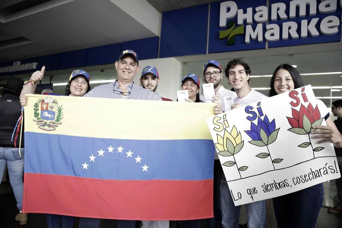 Venezolanos que residen en Costa Rica posan con una pancarta y una bandera durante la votación de una consulta popular impulsada por la oposición venezolana contra el proceso Constituyente el domingo 16 de julio de 2017, en San José (Costa Rica).