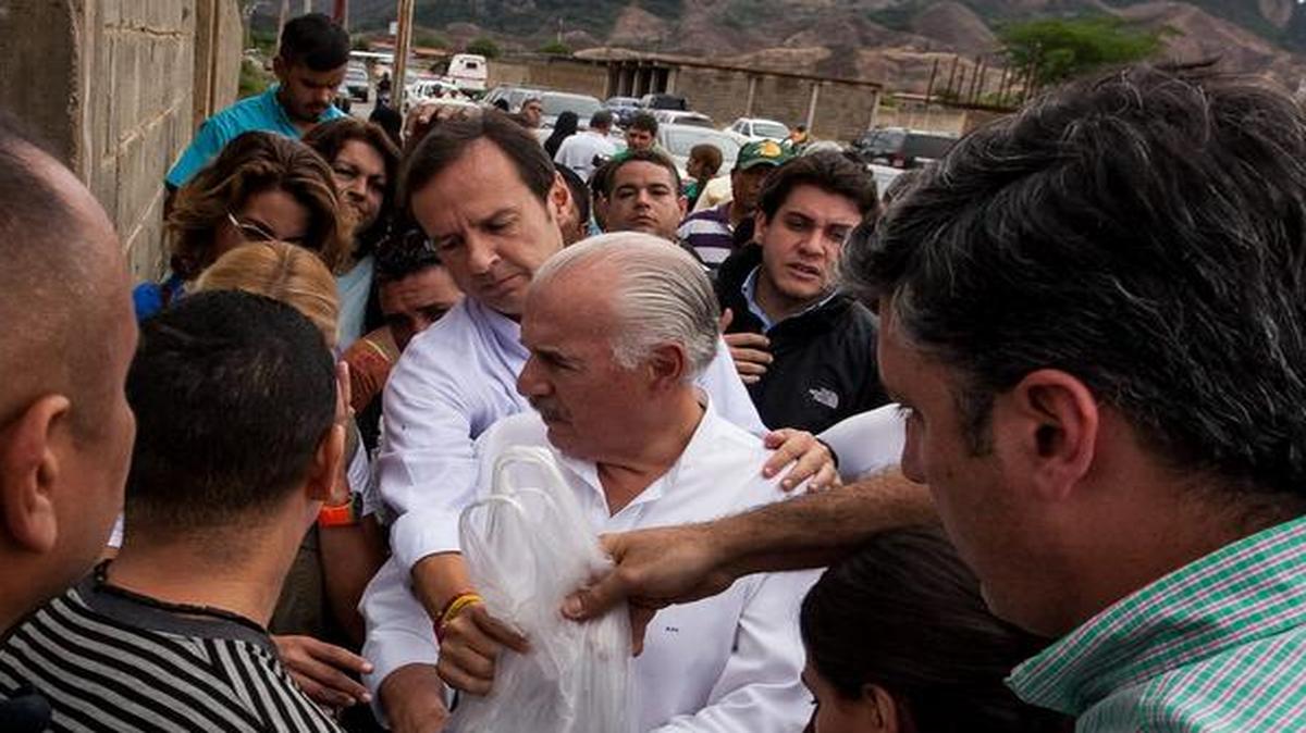 
Los ex presidentes de Bolivia, Jorge Quiroga (centro-atrás), y Colombia, Andrés Pastrana (centro-adelante), entregan una bolsa con insumos para el opositor venezolano Daniel Ceballos el viernes 29 de mayo del 2015, en la entrada del Centro de Reclusión 26, en la ciudad de San Juan de Los Morros, Venezuela.
