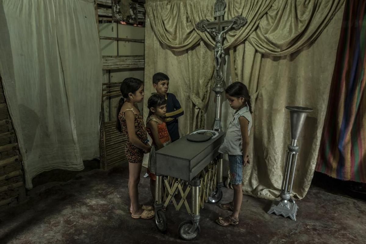 Cuatro niños asisten al funeral de su primito Kenyerber Aquino Merchán, de 17 meses de edad, que murió de desnutrición en San Casimiro, Venezuela.