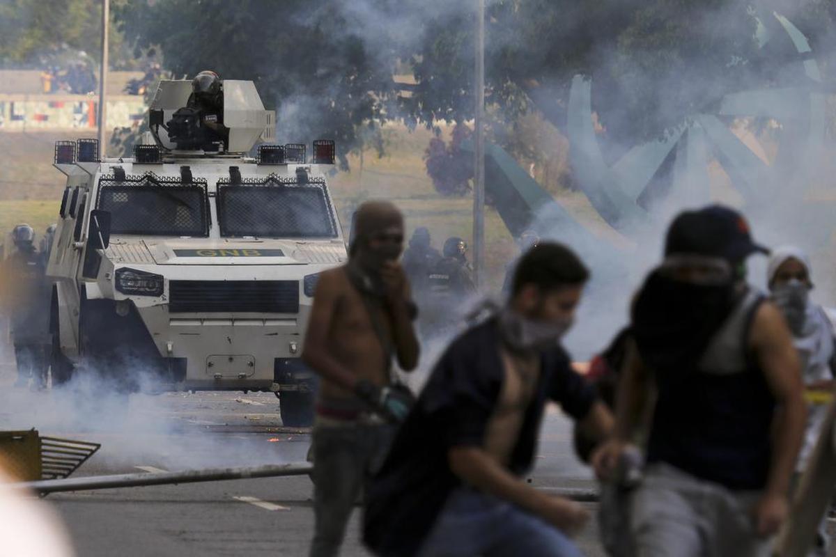 Un vehículo blindado de la Guardia Nacional Bolivariana se enfrenta a los opositores al presidente Nicolás Maduro en una marcha de la oposición en el centro de Caracas, Venezuela, el miércoles 26 de abril de 2017.