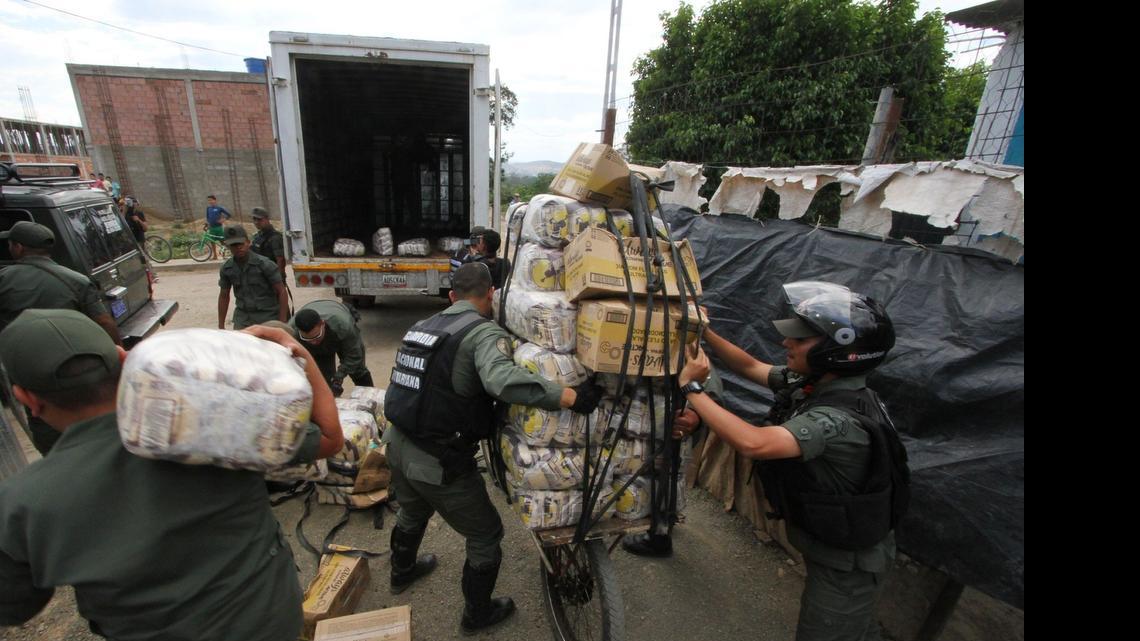 
Agentes de la Guardia Nacional Bolivariana recogen mercancía que le fue decomisada a contrabandistas en San Antonio, Venezuela, en la frontera con Colombia, el 9 de marzo.
