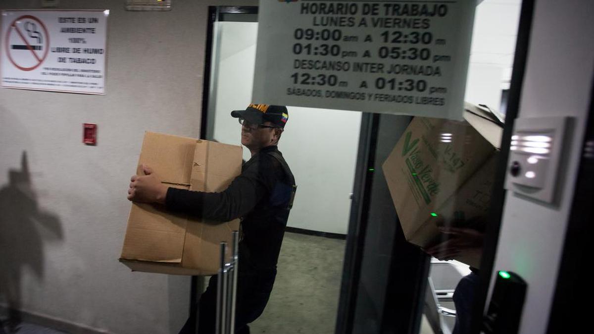 Funcionarios de la Dirección General de Contrainteligencia Militar (DGCIM) sacan cajas de una de las oficinas de la Federación Venezolana de Fútbol el jueves 17 de diciembre de 2015, en la ciudad de Caracas (Venezuela). 