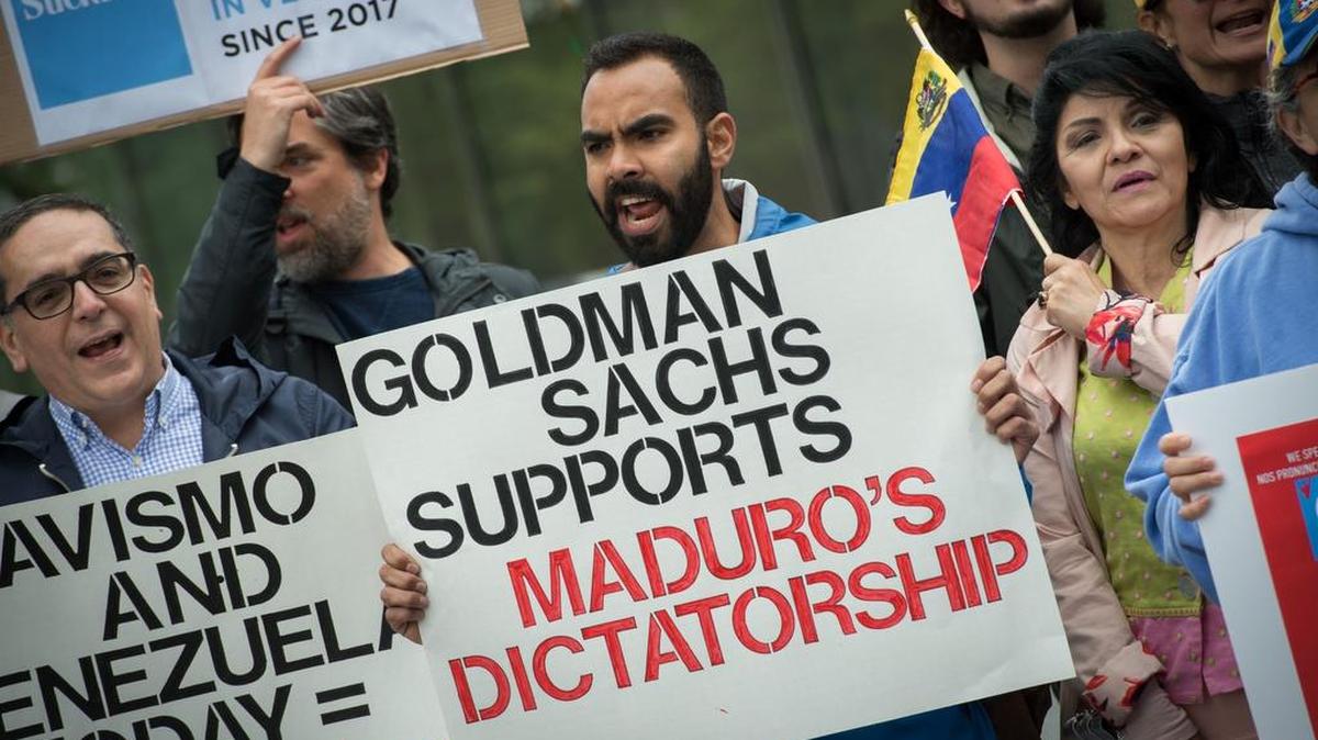 Activistas sostienen carteles durante una protesta contra la transacción de compra de bonos de Goldman Sach con el venezolano Nicolás Maduro fuera de la sede de Goldman Sachs el 30 de mayo de 2017 en Nueva York.