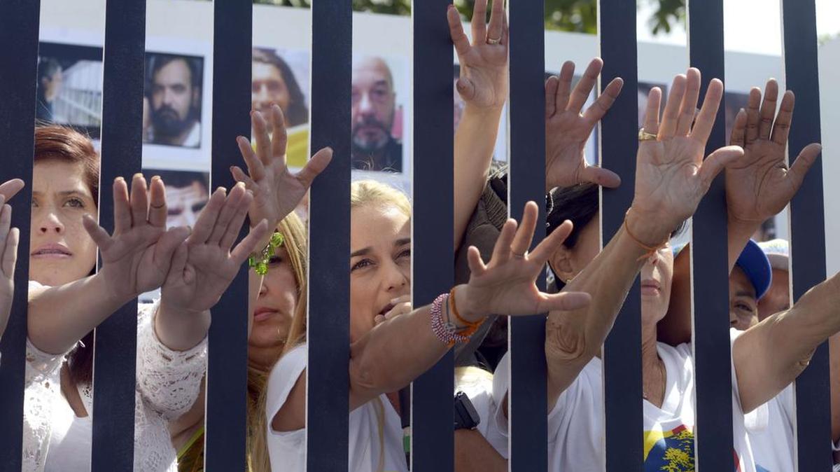 La esposa del líder de la oposición venezolana Leopoldo López, Lilian Tintori, junto a familiares de otros presos políticos, es vista el lunes 14 de diciembre de 2015, en una representación de celda de madera haciendo referencia a los presos y pidiendo la liberación de los mismos en Caracas.