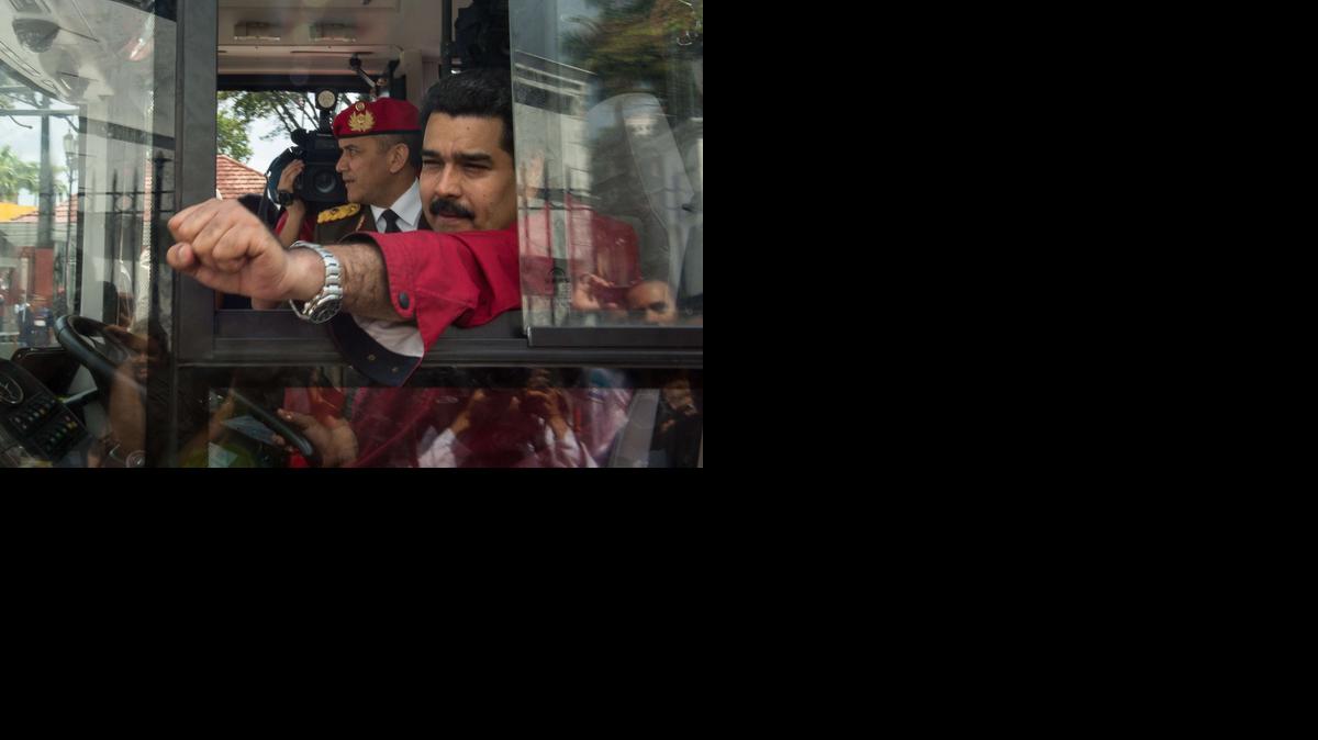 
El mandatario Nicolás Maduro saluda mientras maneja un autobús, tras su llegada a Caracas el 17 de enero de 2015. 
