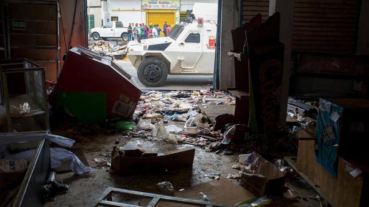 Un vehículo de la Guardia Nacional venezolana está estacionado frente a un supermercado saqueado en Ciudad Bolívar, estado de Bolívar, Venezuela, el 19 de diciembre de 2016.
