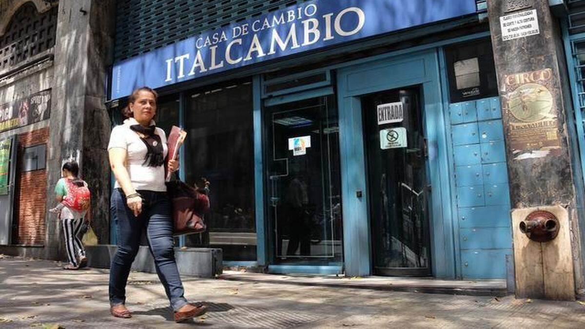 
Una mujer camina el miércoles frente a una casa de cambio en Caracas.
